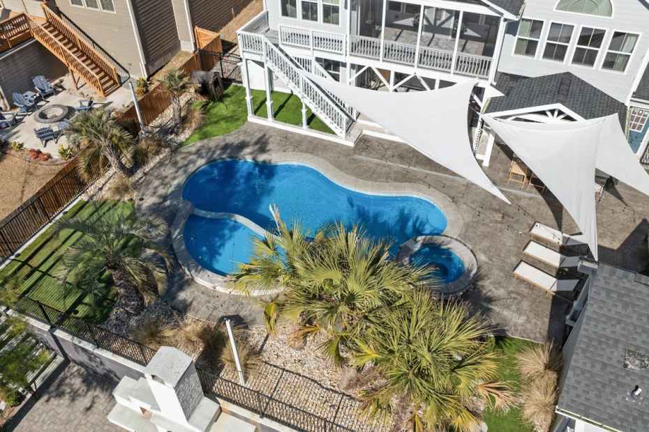 Aerial view of backyard pool with concrete deck